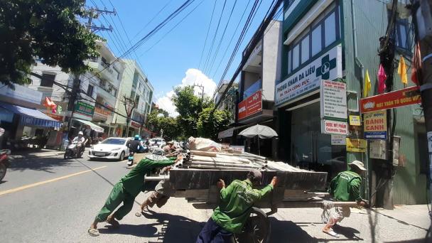 Four outdoor workers push material in extreme heat 