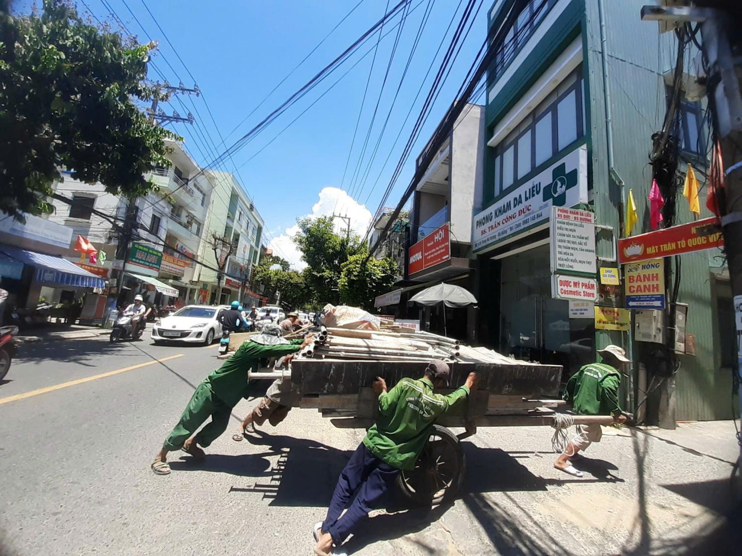 Four outdoor workers push material in extreme heat 