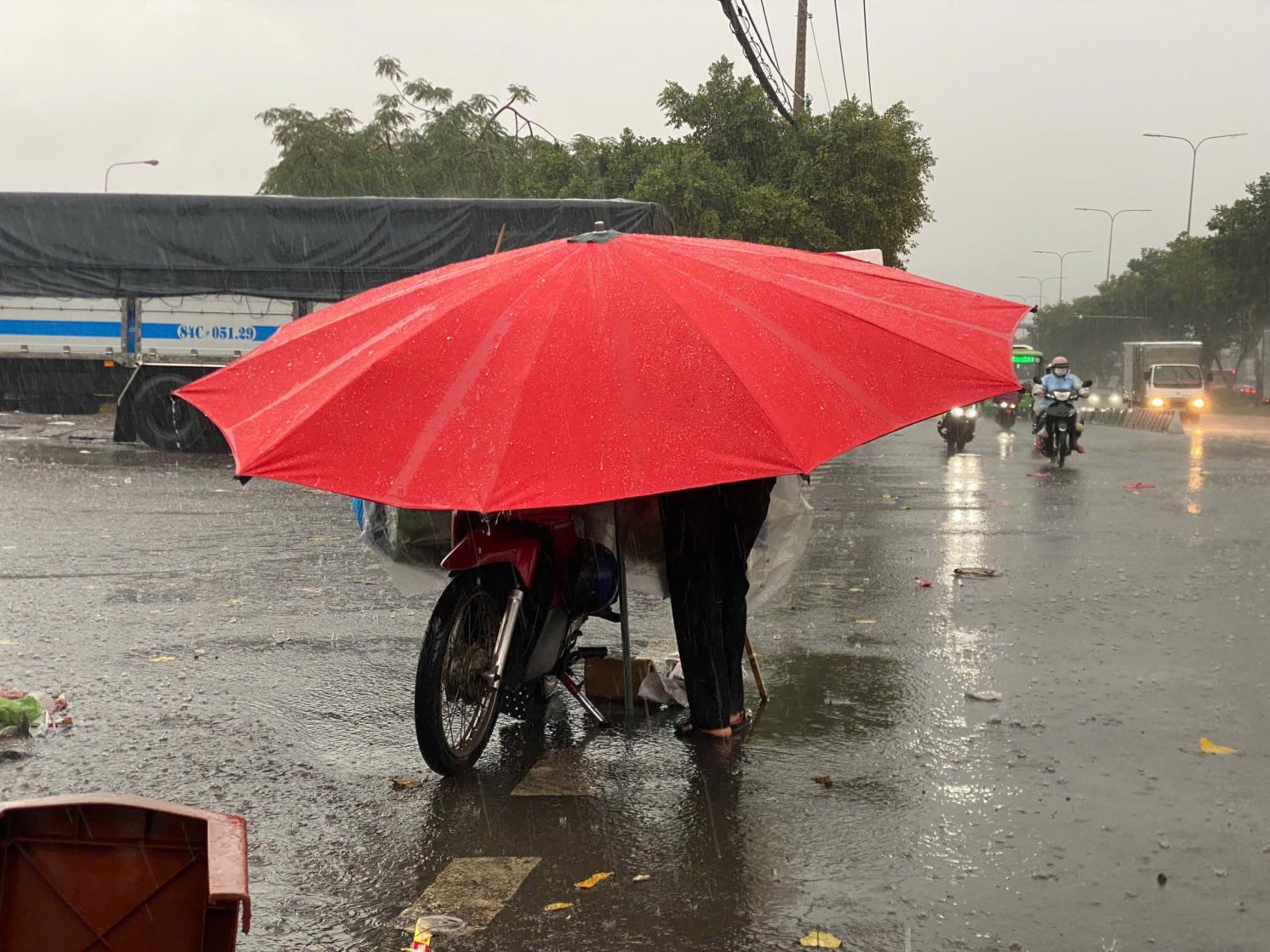 Cyclist using umbrella in heavy rainfall in Vietnam